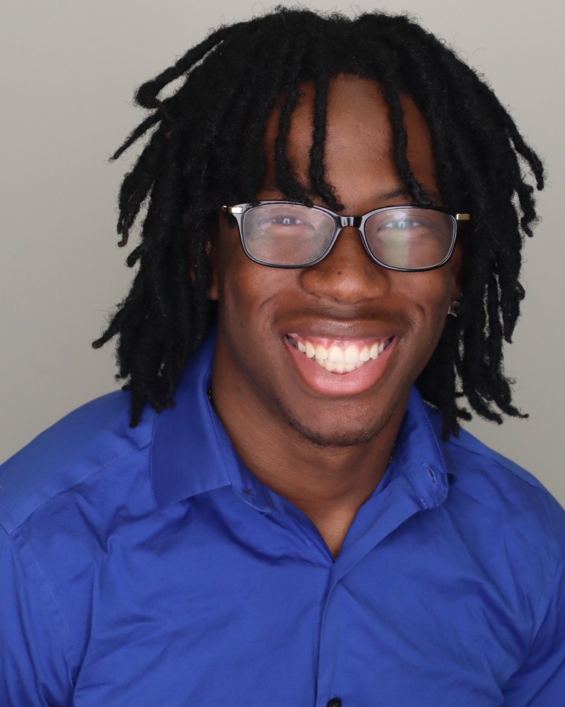Headshot of Brentley Dorsainvil smiling in glasses and a blue button-down shirt